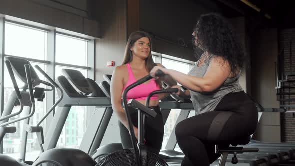 Charming Plus Size Sportswoman Smiling To the Camera Working Out on Air Bike