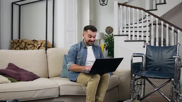 Bearded Disabled Guy Celebrating Victory After Seen Good News on Computer Screen alt