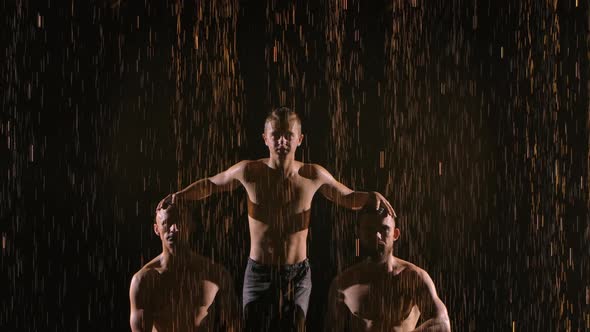 A Young Artist Acrobat Sits on a Twine in the Air with the Support of Two Assistants. Acrobatic Show alt
