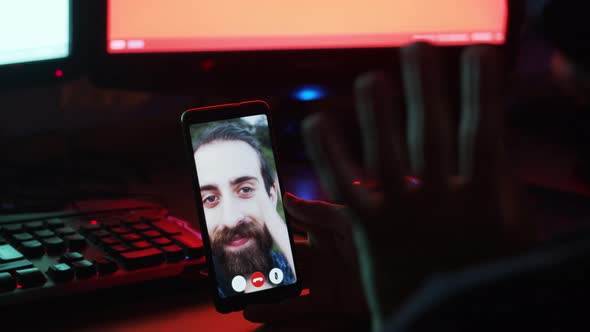 The man is making a video call in his room with hipster man using video