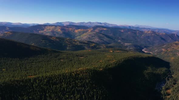 Aerial 4k wide shot. Drone flying over scenic fall colors in the Colorado Rocky Mountains.