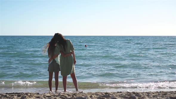Beautiful Mother and Daughter on the Beach Enjoying Summer Vacation