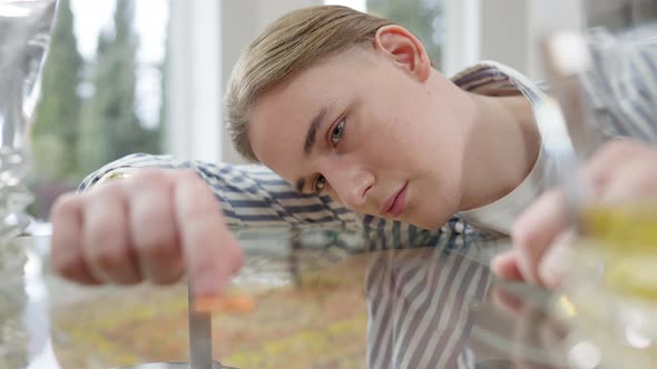 Closeup Portrait of Depressed Sad Man with Head on Table Moving Pills with Finger alt