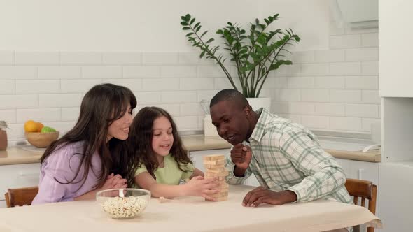 Cheerful Family of Different Races Play Board Game at Home alt
