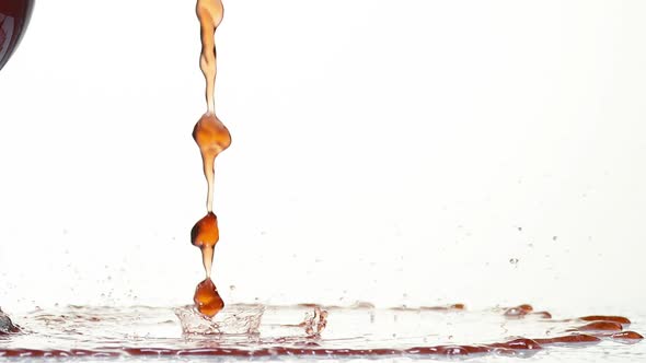 Red Wine being poured near Glass, against White Background, Slow motion
