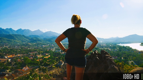 Rear View of Carefree Woman Taking in Scenic Top View of City and Mountains alt