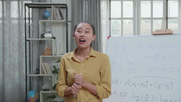 Asian Female Teacher With Marker Pen Teaching Math At Home alt