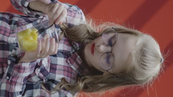 Girl Eating Pineapple From Plastic Cup alt