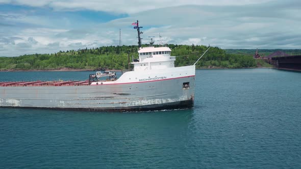 Lake freighter transporting cargo on Lake Superior in Duluth Minnesota against cloudy afternoon sky alt