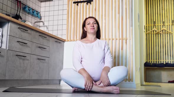 Young Pregnant Woman Going Yoga Exercise at Kitchen