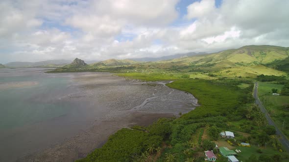 Fiji Travel - Mid Tide Aerial Drone Flight Panorama of mountains near the ocean. alt
