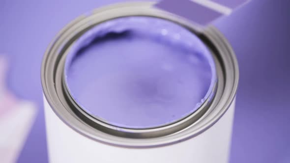 Close up of metal paint can with purple paint and paint swatch. alt