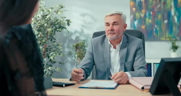 Job Interview Elderly Boss with Gray Hair Sitting at Desk Opposite Him Woman Applying for alt