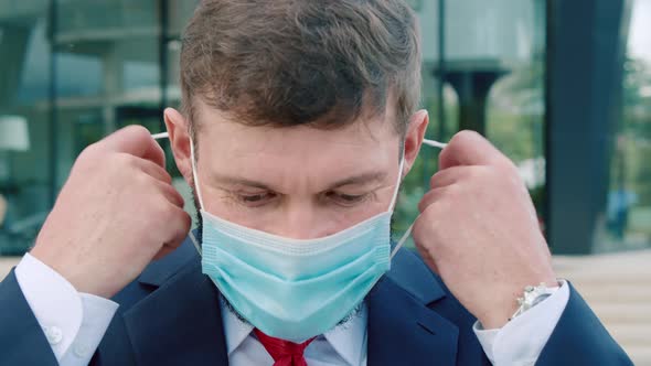 Portrait of a Senior Engineer with a Beard in a Business Suit Looking at the Camera Removing a alt