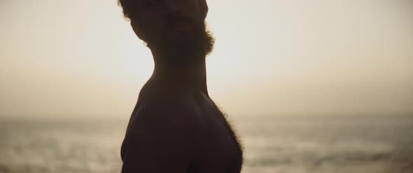Man stretching his neck in front of the sea alt