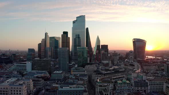 Circling aerial drone shot of Central London skyscraper buildings at sunrise close up alt