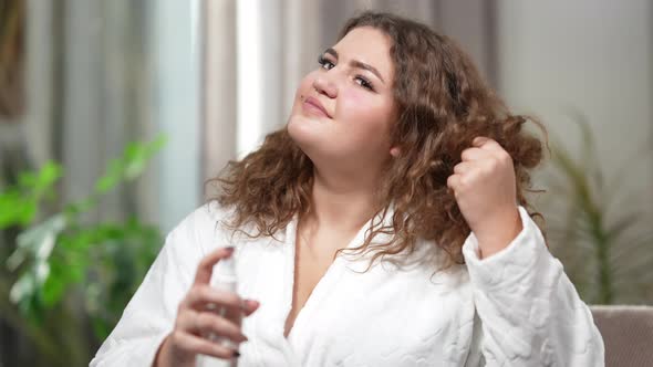 Portrait of Young Caucasian Chubby Woman Spraying Hair Spray Smiling alt