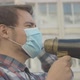 Side View of Young Male Activist in Face Mask Shouting Through Megaphone. Close-up Portrait - VideoHive Item for Sale