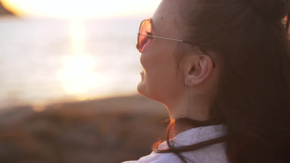 Shooting Over Shoulder of Cheerful Young Smiling Woman Dancing in Slow Motion in Sunbeam Outdoors alt