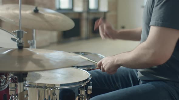 Musician Playing Drum Set while Rehearsing in Studio alt
