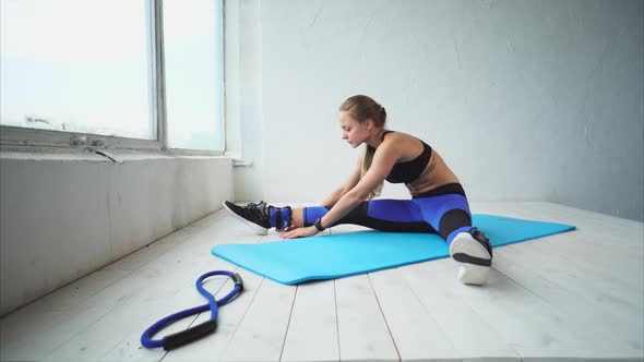 Legs and Torso Stretching. Attractive Woman in Sportswear Doing Stretching alt