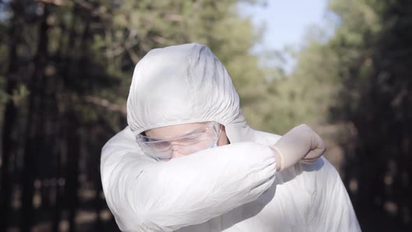Portrait of Young Man in Safety Suit Sneezing or Coughing and Showing Thumb Up. Caucasian Virologist alt