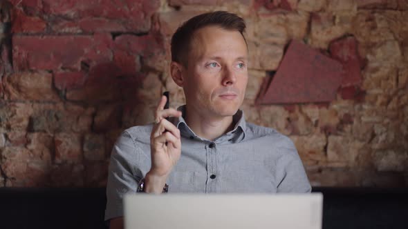 Thoughtful Serious Young Man Student Writer Sit at Home Office Desk with Laptop Thinking of alt