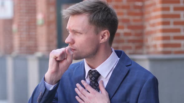 Portrait of Sick Businessman Coughing at Work alt