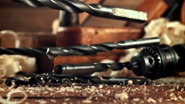 Drill Bits Fall on a Table of Sawdust alt