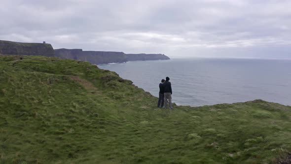 Aerial View of Beautiful Irish Cliffs Young Couple Admire Watch the Landscape Panorama Hand in Hand