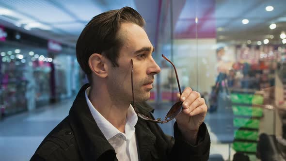 Beautiful Male Thinks About Windows Store To Buy the Product alt