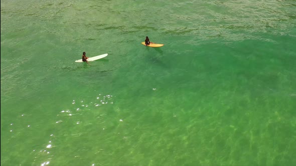 4K Aerial view group of Asian woman surfing in the sea at tropical beach. alt