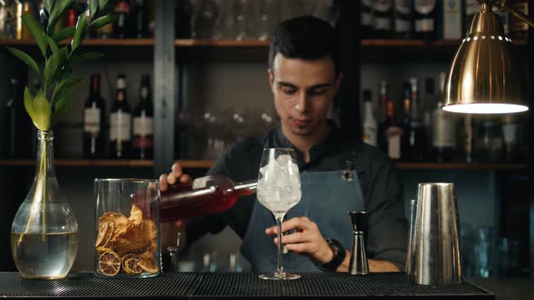 The Barman Pours Aperol Into the Cocktail of Aperol Spritz Close Up Bartender Make Alcohol Drink alt