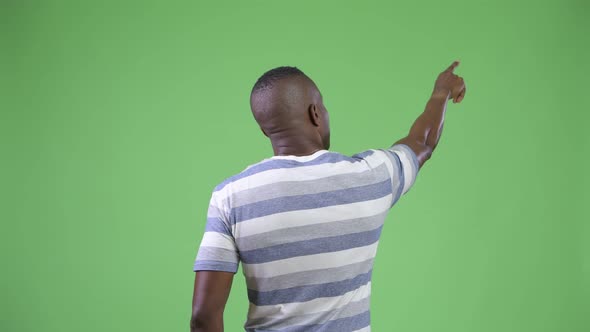 Rear View of Young African Man Directing and Pointing Finger alt