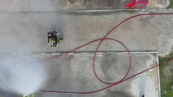 Top or aerial view of fireman with girlfriend enjoy with water spraying by man hold girlfriend alt