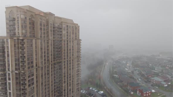 AERIAL - A thick fog, mist, covers Ottawa, Canada, wide shot pan left alt