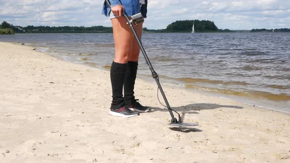 Woman With Metal Detector On Sand