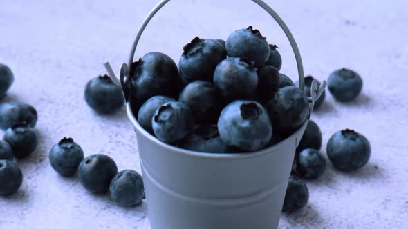 Blueberries in a Small Bucket on Concrete Background alt