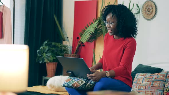 African-american Woman Is Being Joyful During a Videocall From Home alt