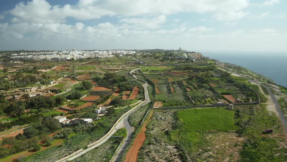 AERIAL: Greeny Landscape on Dingli Cliffs During Winter with Farmland and City in Background