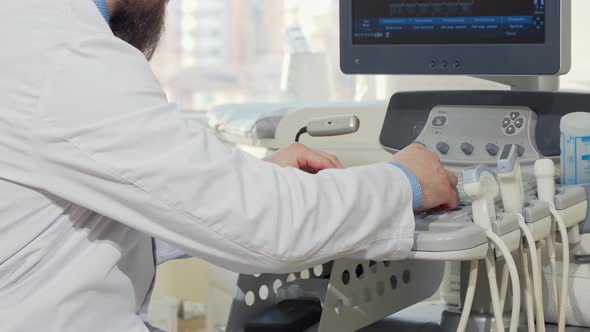 Cropped Rear View Shot of a Male Doctor Using Ultrasound Scanner alt