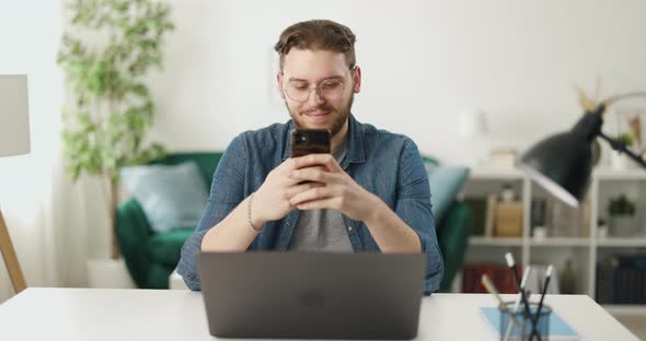 Man with Mobile and Laptop at Home