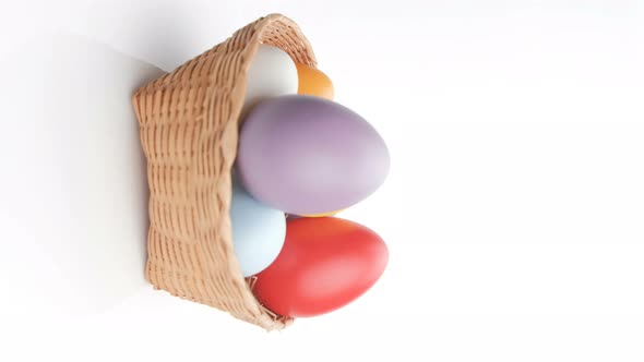Rotating colorful easter egg in a basket isolated on white background.