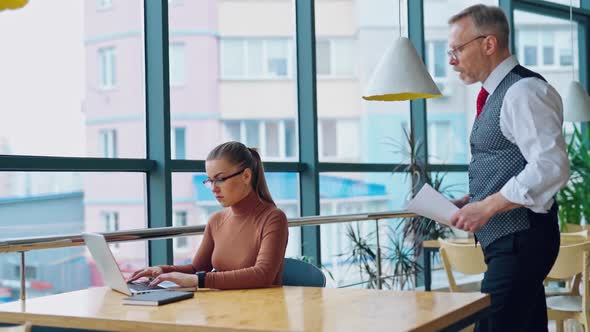 Young woman working on a computer near the window. alt
