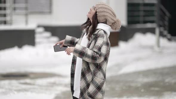 Woman Is Walking Alone at Winter and Taking Photo of Nature and City By Camera of Cell Phone alt