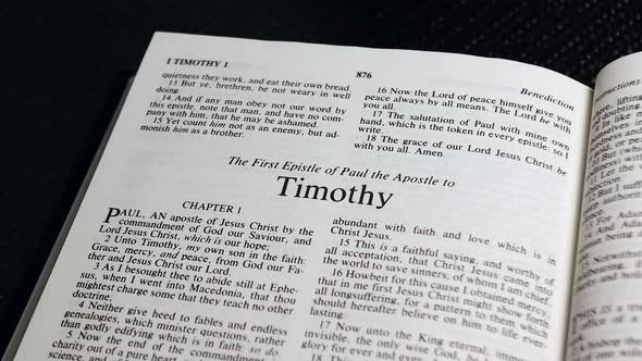 Close Up Shot of  Bible Page Turning to the book of First Timothy alt