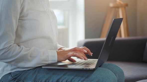 Close-up Woman Working on a Laptop Against the Sunset. Concept of Remote Work. alt