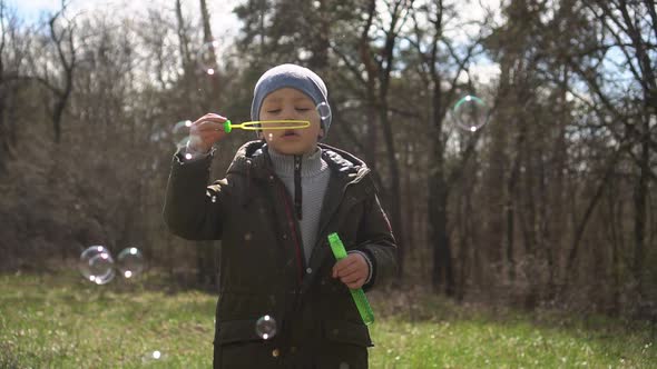 Little Boy Blowing Soap Bubbles in the Park.slow-mo