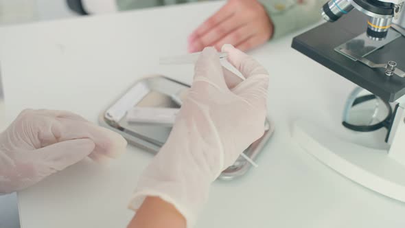 Close up of Asian doctor using a rapid antigen test doing quick swab for patient during Covid 19. alt