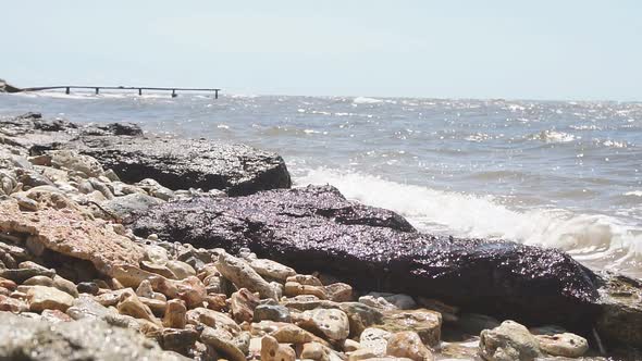 Large Rocks Boulders on the Seashore Waves Crashing Against Rocks Slow Motion on a Sunny Day